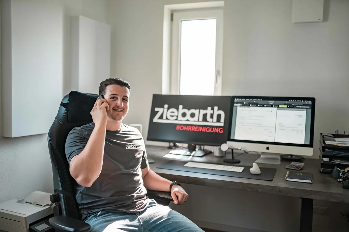 Maximilian Ziebarth berät einen Kunden am Telefon im Büro von Rohrreinigung Ziebarth